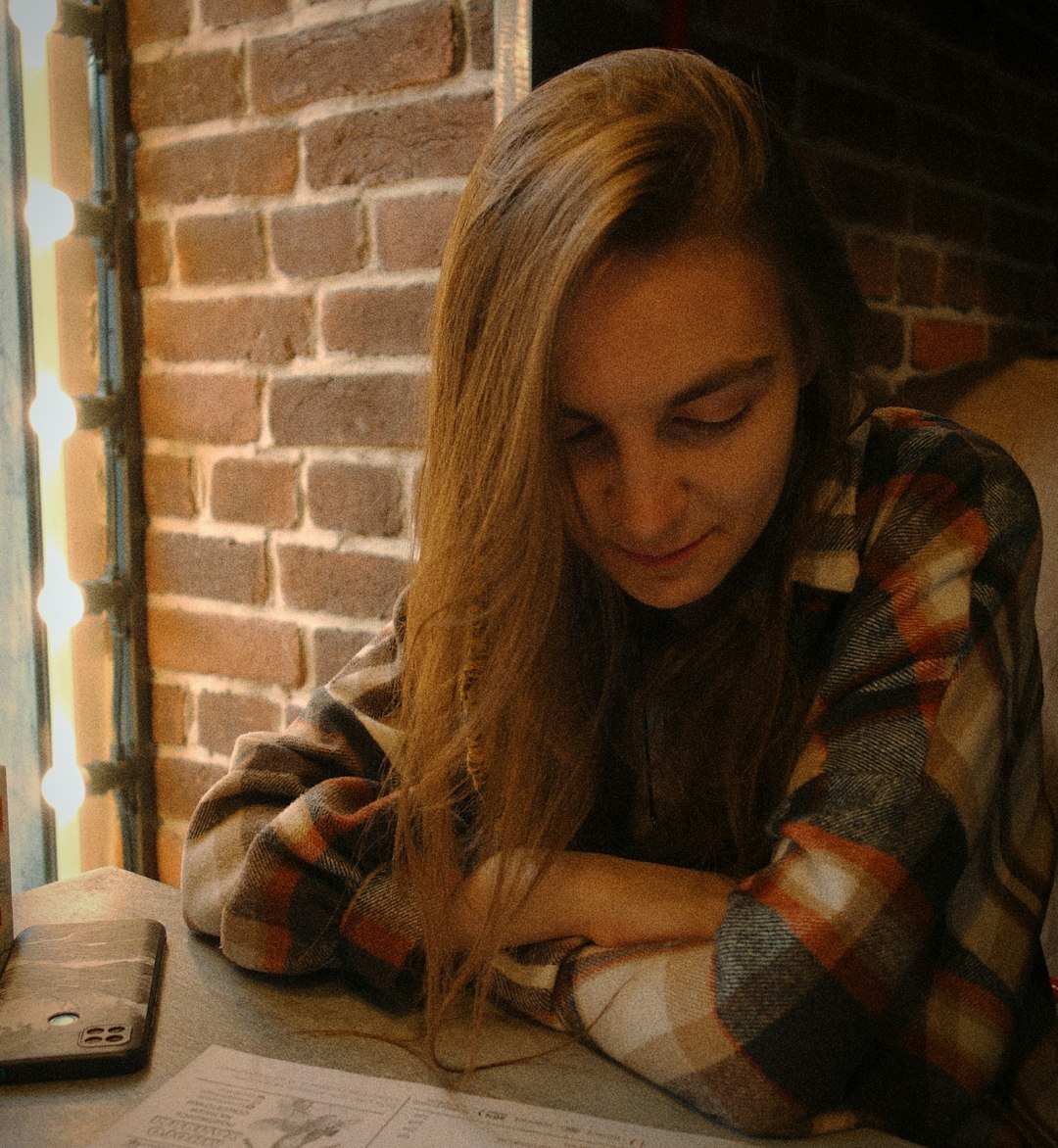 Brazilian woman writing in a notebook while smiling confidently