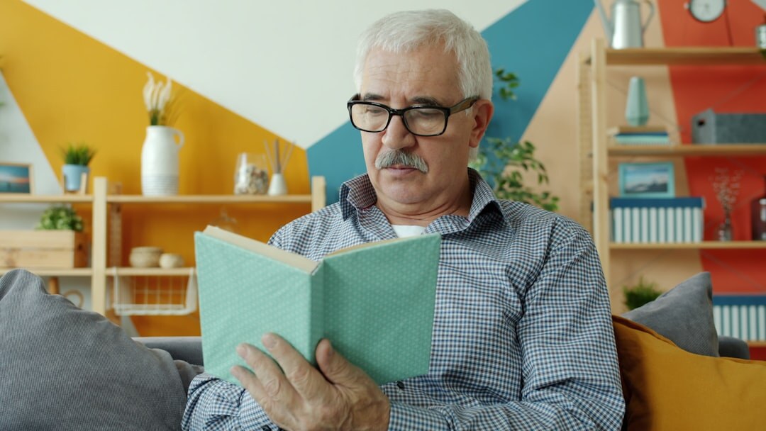 person reading book in cozy room