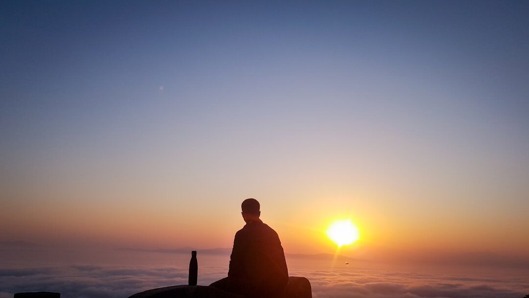 person meditating at sunrise