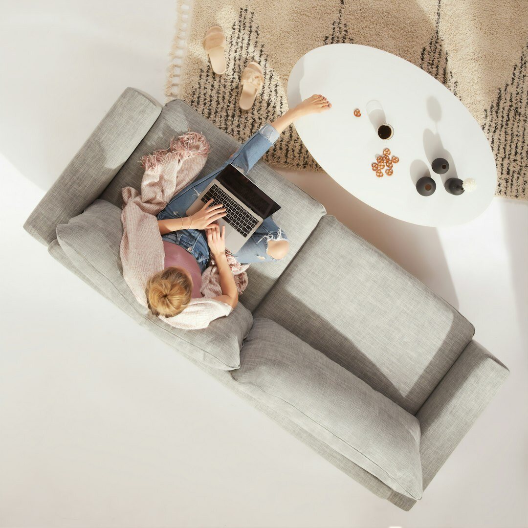 Young Brazilian man reading a book on a cozy sofa